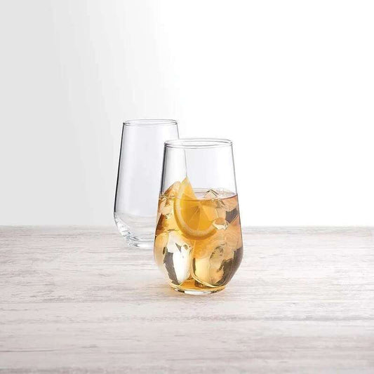 Clear glass with lemon and ice on a light wooden surface