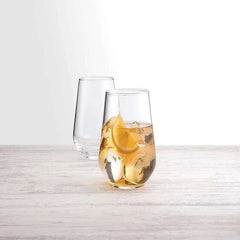 Clear glass with lemon and ice on a light wooden surface