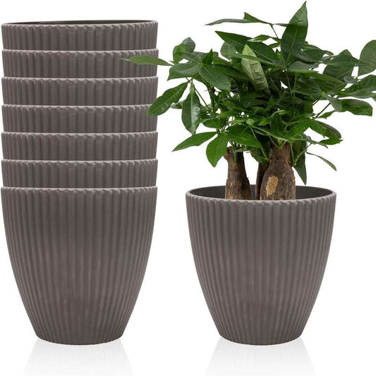 Set of gray ribbed planters with a single potted plant on a white background